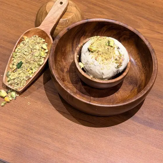 Pistachio ice cream in a wooden bowl